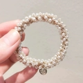 Élastique à cheveux élégant avec perles crème, cordon tressé doré et breloque ronde - Style Perle