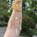 Macro detail of moon sun catcher with yellow crystals and colorful prisms in sunlight - Citrine
