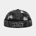 Dettaglio del cappello docker in denim nero lavato con ricamo e fori consumati - Regolabile / Nero