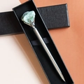 Close-up of a silver metal pen with green raw gemstone crystal in a black gift box - Aventurine Jade