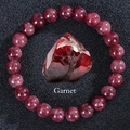 Macro detail of garnet beaded bracelet with a large faceted red garnet centerpiece - Garnet