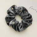 Primer plano de coletero de terciopelo gris oscuro con estrellas doradas y textura - Colección Estrella / Gris