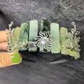 Detailed close-up of handmade crown with green natural stones and silver sun ornament - Prehnite + Sun + Branch