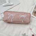 Detail van roze canvas etui met wit strikborduursel en een handig zijhandvat - Nude Roze