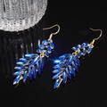 Detail shot of elegant blue leaf tassel earrings with gold metal on a dark reflective surface - Ear Hook-Blue