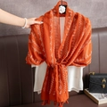 Lightweight orange linen scarf with white geometric patterns and tassels on a hanger - Orange