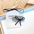 Pince à cheveux élégante avec perles argentées et nœud en velours noir sur carton - Pince à Bec de Canard Perle Argentée Nœud Noir