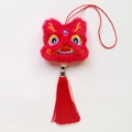 Gros plan détaillé d'un pendentif de danse du lion en peluche rouge avec pompon - Dragon de Bon Augure / Rouge