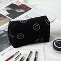 Detail of black corduroy makeup bag with white embroidered smiley face and silver zipper - Black