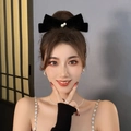 Close-up of a woman wearing a black velvet bow hair clip with elegant pearl embellishments - 15# Velvet Bow Hair Clip - Black Two Pearls