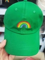 Close-up of bright green cotton baseball cap featuring colorful rainbow embroidery on front - Green