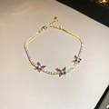 Detailed close-up of golden butterfly tennis bracelet with purple marquise stones and zircon - Gold Purple Butterfly