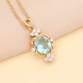 Schicke Goldkette mit hellblauem ovalem Edelstein und funkelnder Kristallumrandung - Hellblau