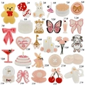 Flat lay of 27 colorful cartoon embroidery patches including bears and hearts - 27-Piece Set