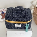 Dettaglio della borsa da trucco trapuntata blu navy con manico e cerniera gialla - Blu