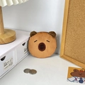 Detailed view of Capybara plush coin purse with closed eyes on a cozy desktop - Happy Expression