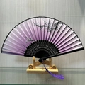 Purple gradient folding fan with black plum blossom pattern and silk tassel on wood stand - Proud Winter Plum (Pink)