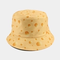 Détail de l'imprimé fromage et de la texture du tissu sur un chapeau bob réversible - M / Jaune