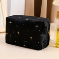 Detailed view of the gold star embroidery on high-quality black velvet makeup bag - Black