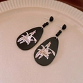 Macro detail of teardrop earrings with shell floral inlay and glossy black bead accents - Silver Pin - Black Waterdrop Earrings