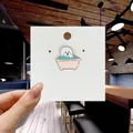 Detail of a cute Bichon dog enamel pin in a pink bathtub shown on a white card display - 130*Dog in Bathtub Pin