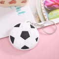 Detailed close-up of a classic black and white PVC football keychain with a silver metal ring - Football