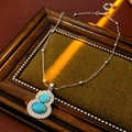 Vintage zilveren ketting met turkoois en diamanten op een groene stofachtergrond - # Ketting-Zilver-Blauw