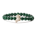 Macro shot of malachite beaded stretch bracelet with a white dolphin charm on white background - Malachite
