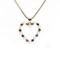 Collana dorata con ciondolo a cuore decorato con perle e gemme colorate su sfondo bianco - Cuore di Pietra Preziosa Colorata Oro con Perla