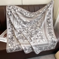 Detail of silk-like square scarf with bamboo print draped over a leather sofa - Gray