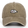 Dettaglio ricamo di una foca su un cappellino in cotone lavato vintage color kaki - Cachi