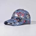 Détail de la casquette de baseball en denim bleu avec imprimé graffiti doré et rouge - Camouflage Métallique Bleu / Bleu