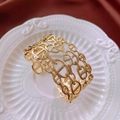 Detailed close-up of golden hollow three-layer chain link open cuff bracelet on white tray - Hollow Three-layer Bangle / Gold