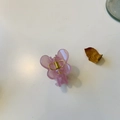 Detailed top view of a pink butterfly hair claw clip with golden spring on white surface - Jelly Pink