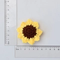 Handmade knitted sunflower charm with yellow petals and brown center with scale measurement - 3-Ring Chicken Yellow Sunflower