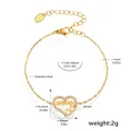 Detail of a golden heart bracelet with AMMAM letters, zircon inlay, and size markings - Gold