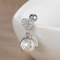 Détail macro d'une boucle d'oreille cœur avec zircone et perle blanche suspendue - Cœur avec Perle Pendante