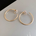 Detail of golden hoop clip earrings with soft transparent silicone pads for comfort - 4cm / Gold / Clip-On Earrings