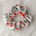 Detail of Christmas scrunchie with holly leaves and berry patterns on white satin - Style 1 (White Christmas Print)