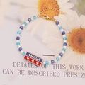 Pulsera de cristal hecha a mano con piedras azules y colgantes dorados de AMOUR - Estilo AMOUR Rojo