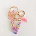 Pink resin alphabet V keychain featuring glitter sequins, butterfly charm, and soft tassel - Letter V