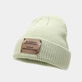 Detail of mint green knit beanie featuring a brown leather patch and fine textures - Light Green