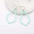 Dettaglio degli orecchini a onde verde menta su un vassoio di marmo elegante - Verde
