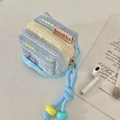 Macro view of blue tweed knit pouch showing gold zipper and colorful beaded handle strap - Blue