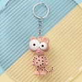 Close-up of a cute pink cheetah PVC keychain with large eyes on a textured background - Classic Leopard