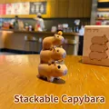 Stackable capybara figurines set with orange accessory on a rustic wooden desk - Triple Stack
