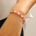 Dettaglio di maglie a forma di cuore con smalto rosa e rosso su un bracciale color oro - Bracciale Cuore Sfumato Oro KC