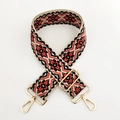 Close-up of ethnic jacquard shoulder strap with red geometric patterns and gold metal hooks - Black Orange Floral