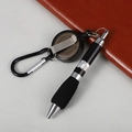 Detail view of a retractable ballpoint pen with carabiner and keychain on a notebook - Retractable Ballpoint Pen / Black
