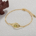 Dettaglio charm foglia con gemma verde e marchio S925 su catenina dorata - Bracciale / Oro / Peridoto